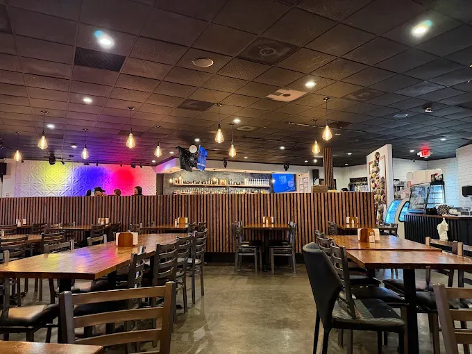 Cozy interior of La Ruana, a Colombian restaurant in Peachtree Corners, with a wooden dining room and bar