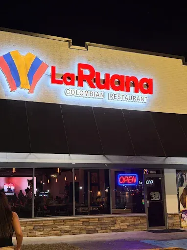 Illuminated storefront of La Ruana Colombian Restaurant at night, with an open sign