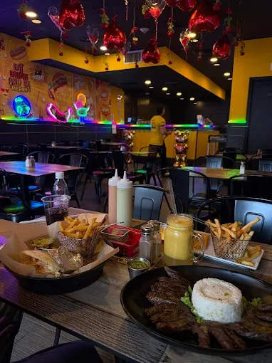 Table of Colombian fast food in the neon setting of Monchy's in New Jersey