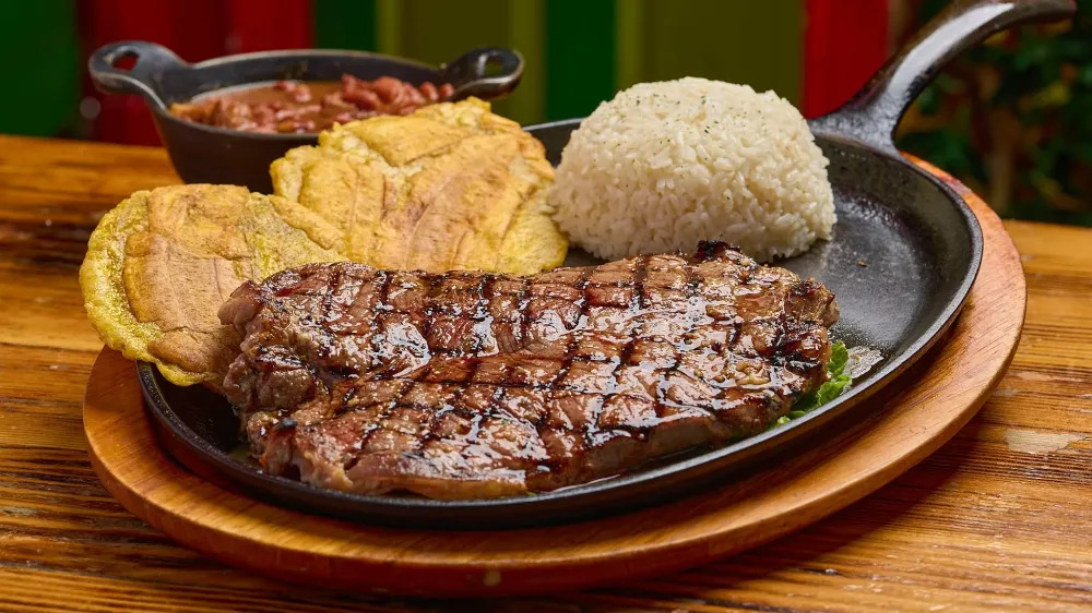 Grilled churrasco with patacones, rice and beans