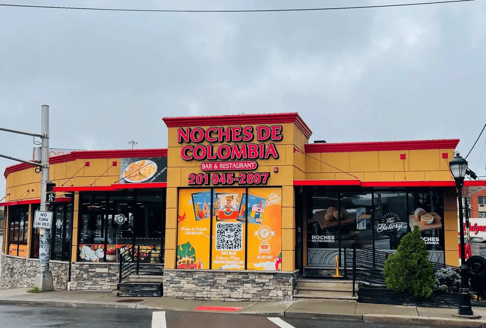 Noches de Colombia storefront with bright yellow facade and bakery and restaurant signage