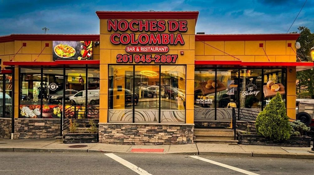 Noches de Colombia storefront with bright yellow facade and bakery and restaurant signage