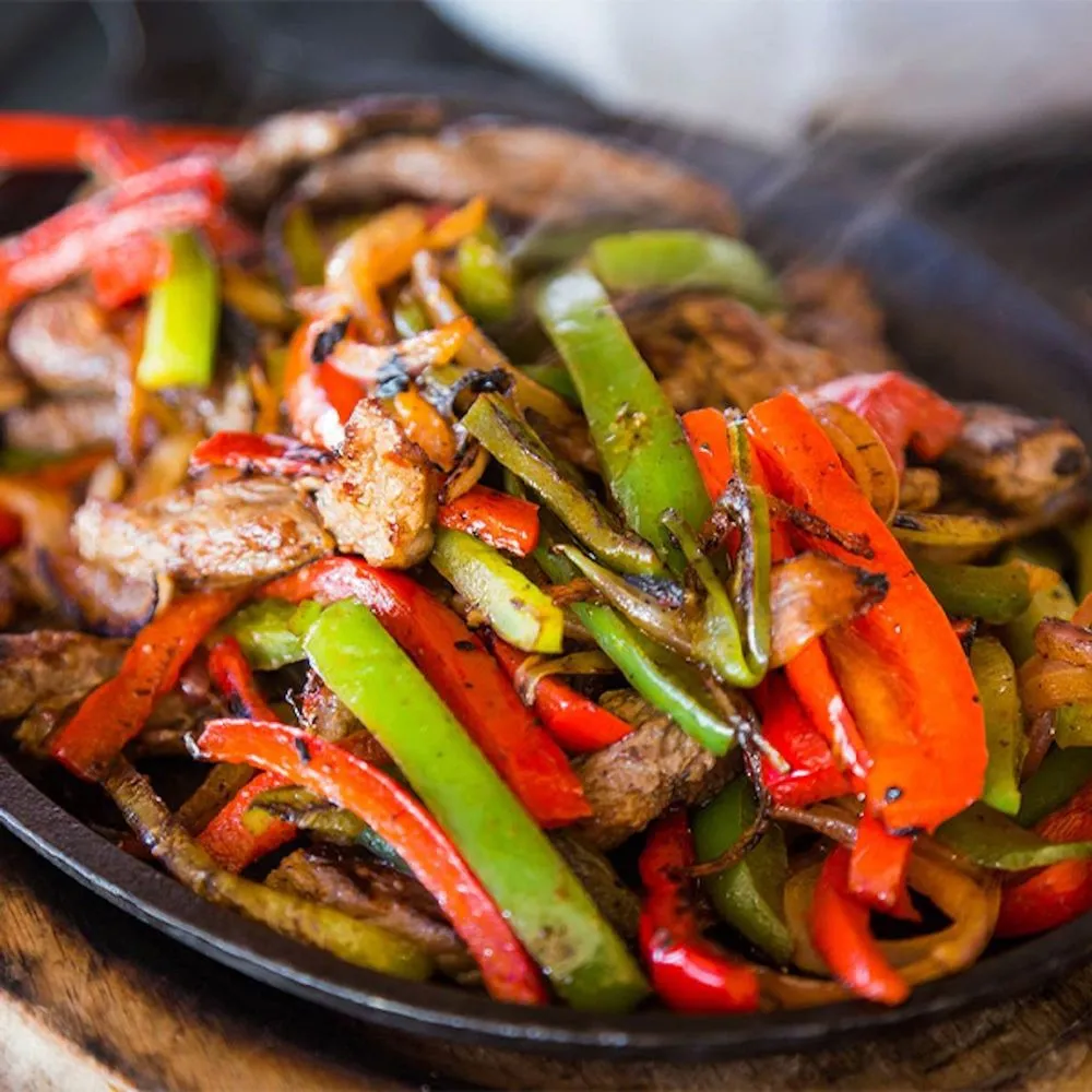 Chicken fajitas served on a sizzling skillet with peppers and onions