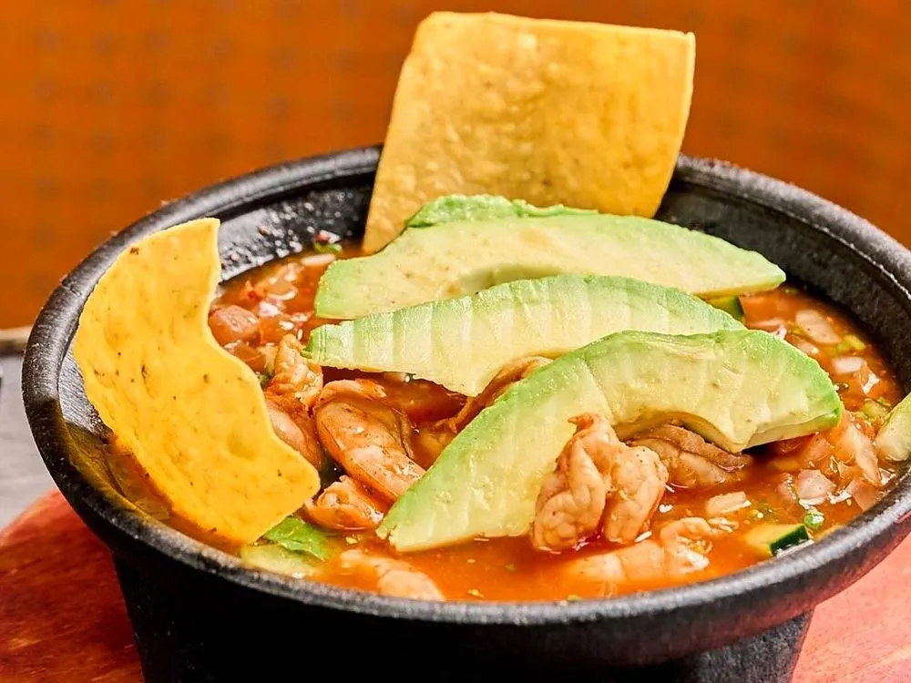 Shrimp cocktail in a molcajete with avocado and tostadas