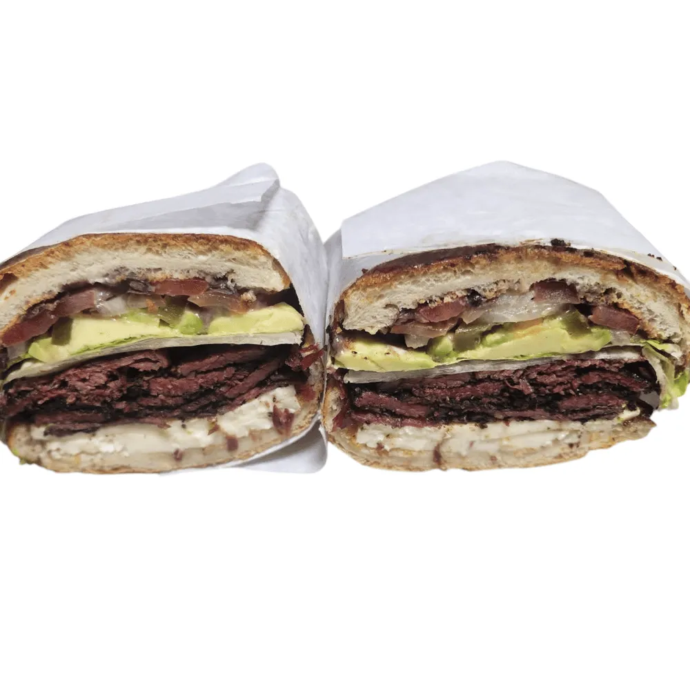 Pastrami torta cut in half, stacked with avocado and fresh cheese