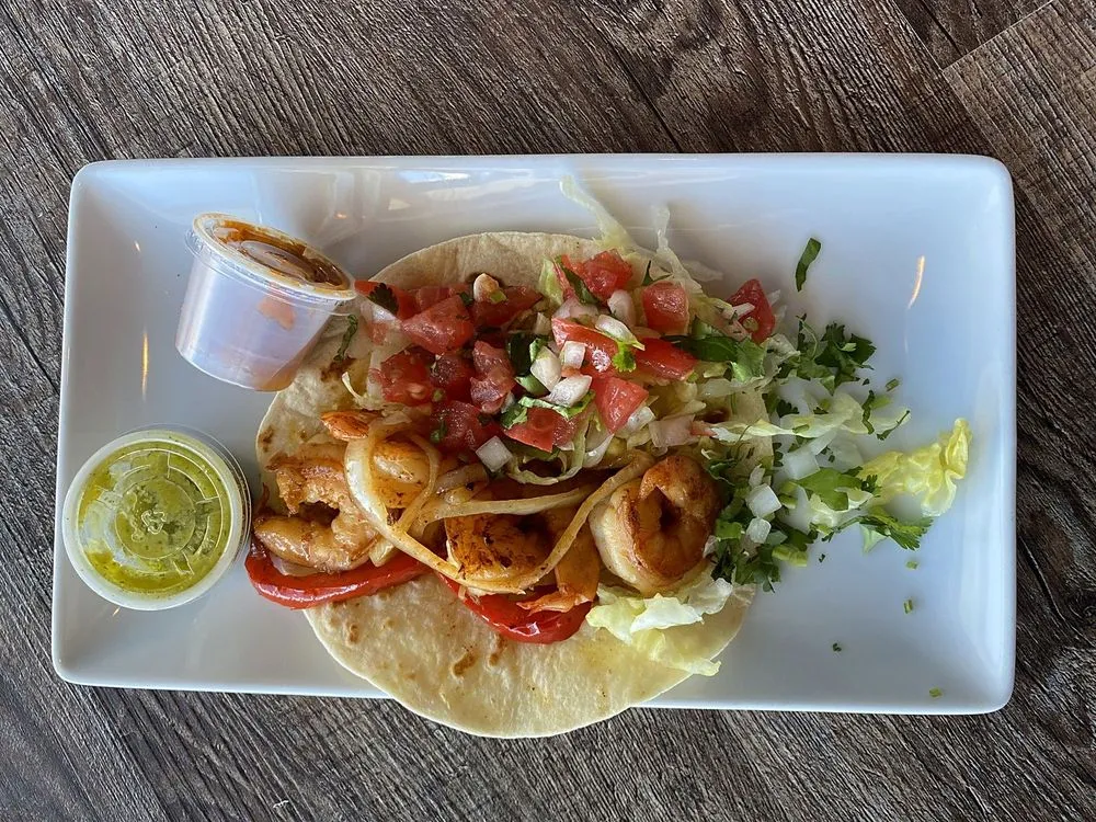Shrimp taco with pico de gallo, peppers and onion