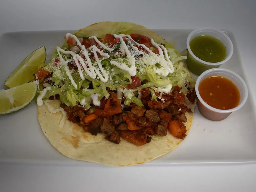 Super Taco with steak, chorizo, lettuce, pico de gallo, cheese and cream on a flour tortilla